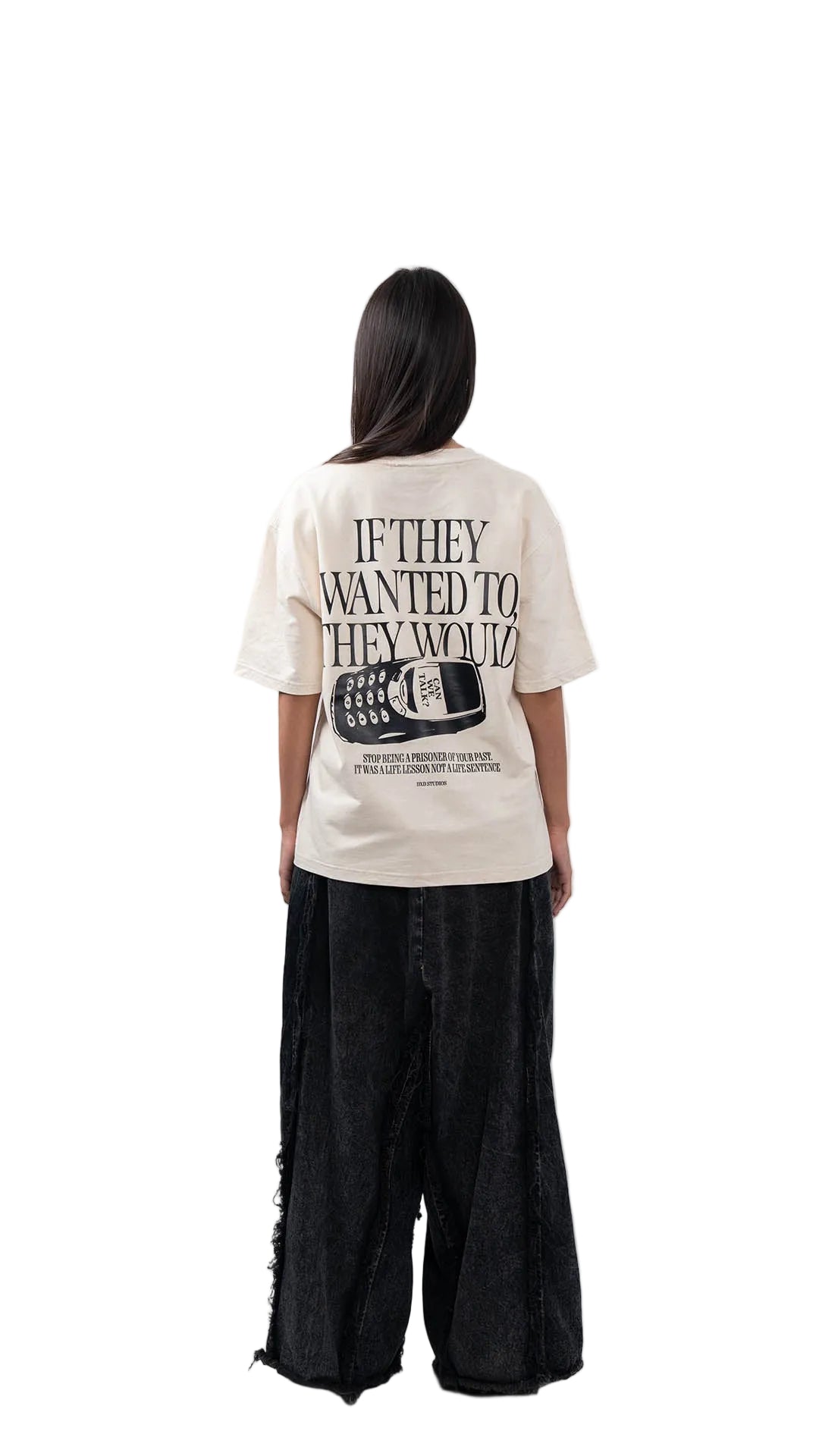 Woman wearing a white oversized t-shirt with dxdstudios logo and black pants on a white background