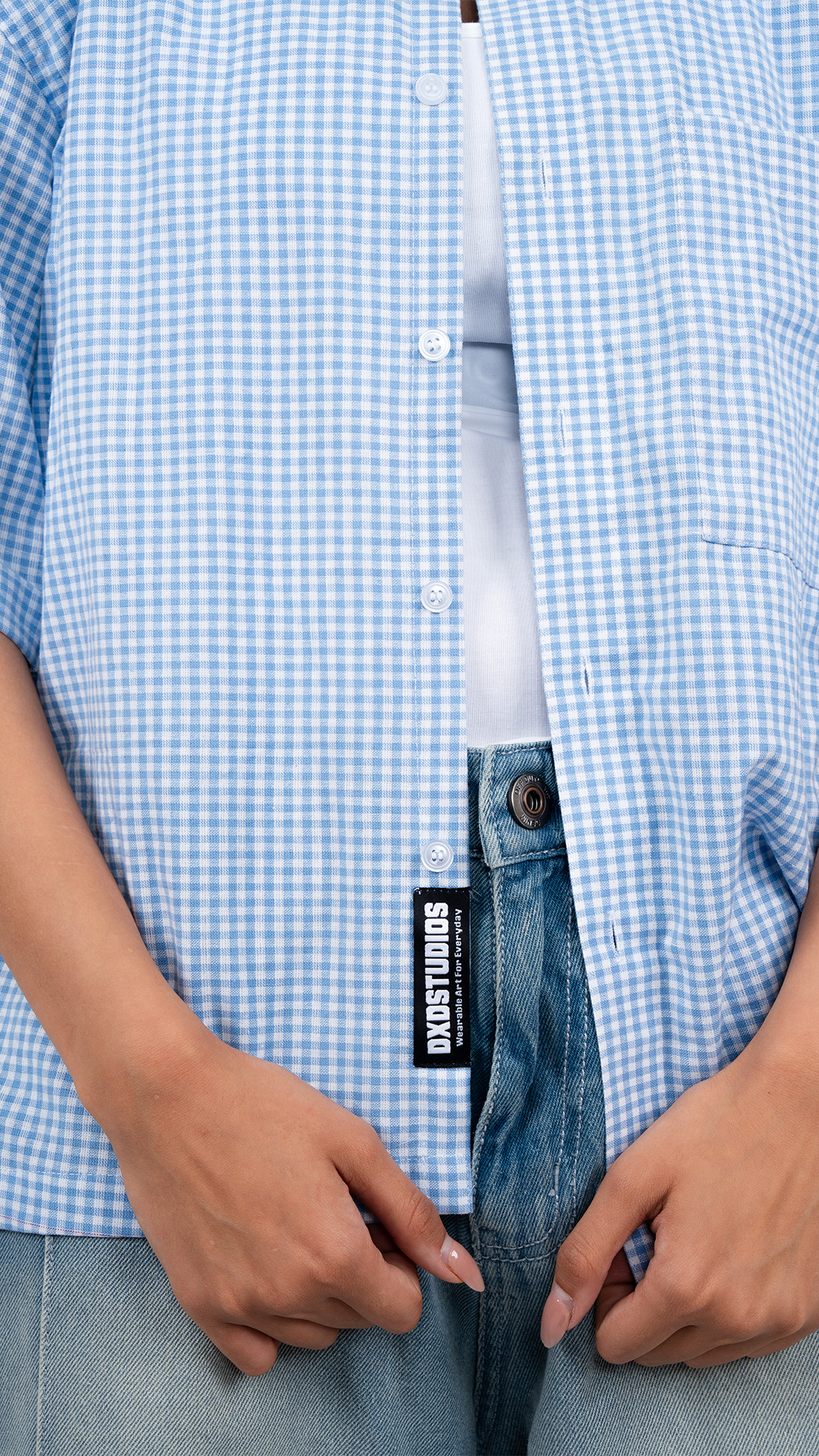 Person wearing a light blue shirt and shorts on a white background