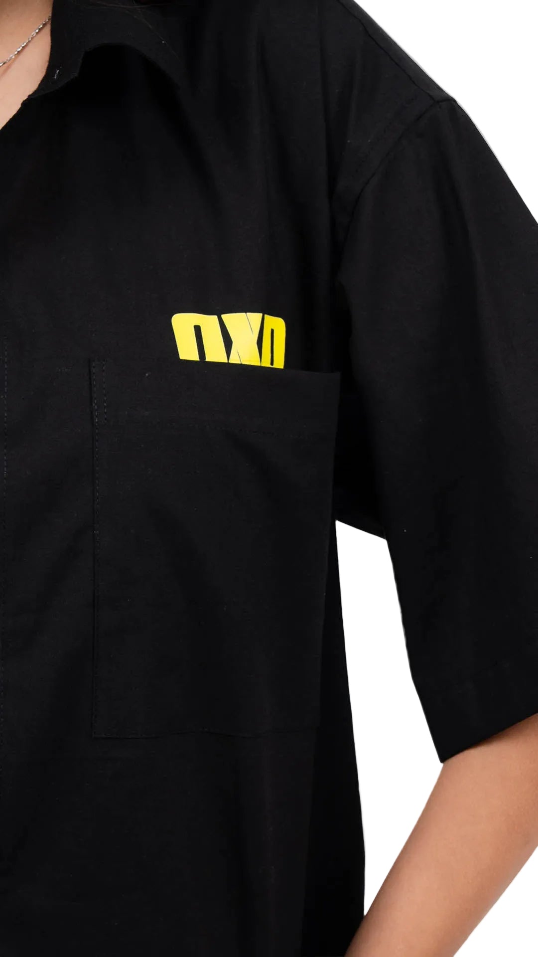 Woman wearing a black jacket with a dxdstudios logo, white shirt, and blue jeans on a white background