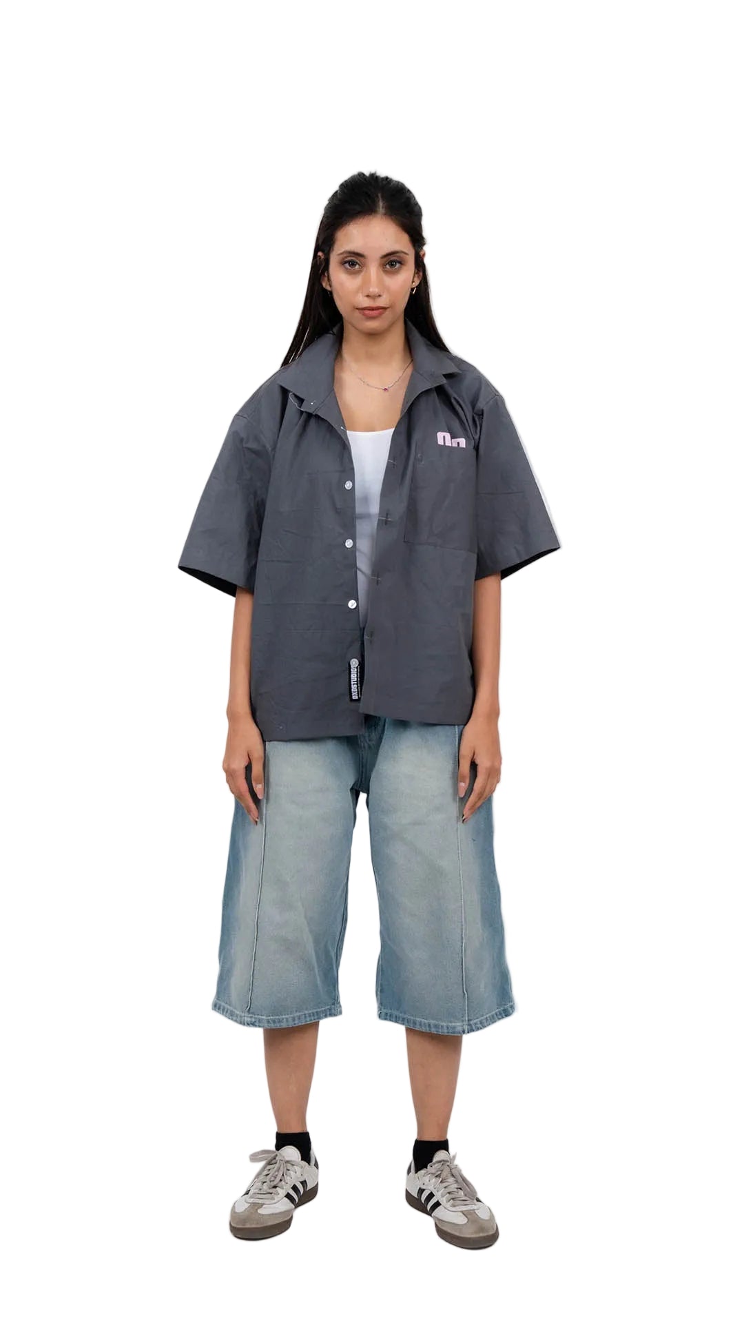 Person wearing a gray shirt and denim shorts on a white background