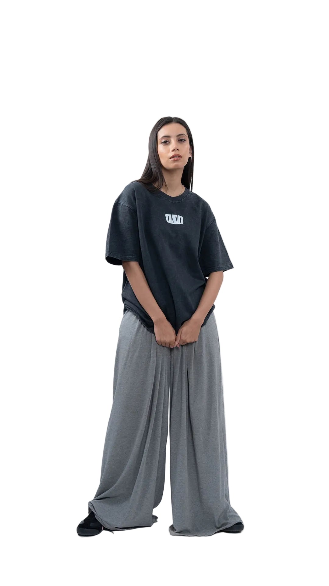 Person wearing a black t-shirt and gray pants on a white background