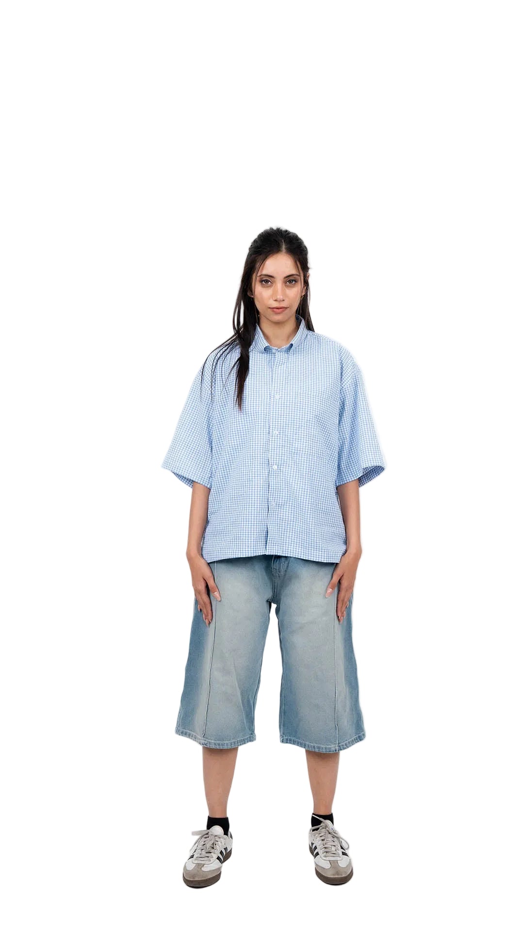 Person wearing a light blue shirt and shorts on a white background