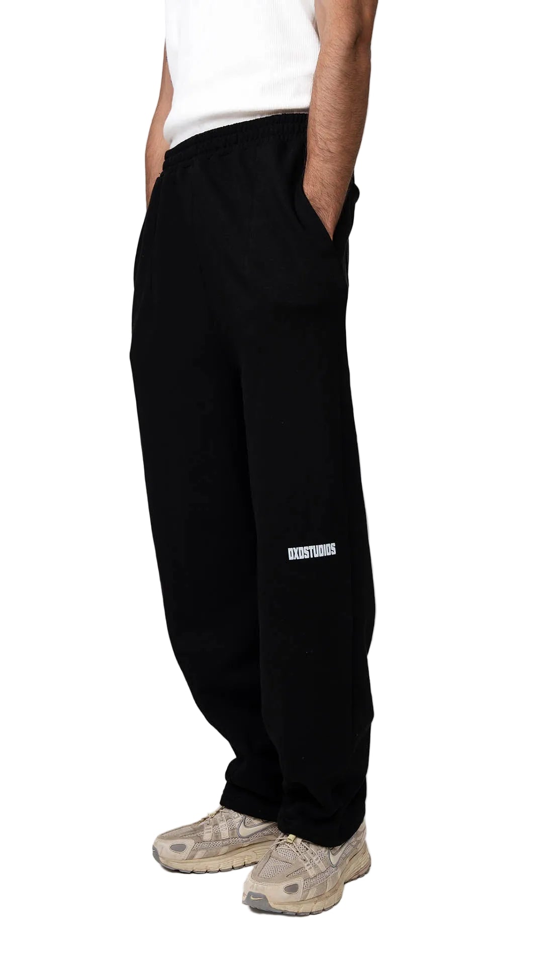 Person wearing a white tank top and black pants on a white background